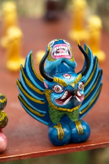 Brightly painted rubber fantasy creature figurine on a wooden surface
