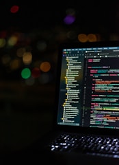 black laptop computer turned on showing music player