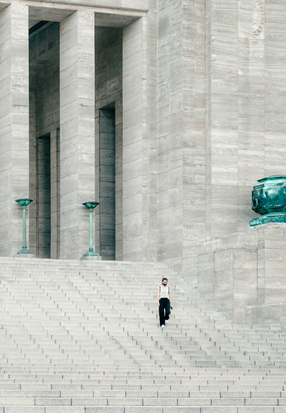 woman in black jacket walking on sidewalk during daytime