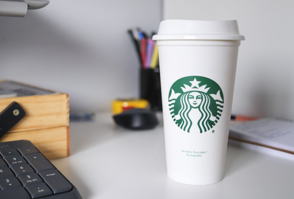 white starbucks disposable cup on white table