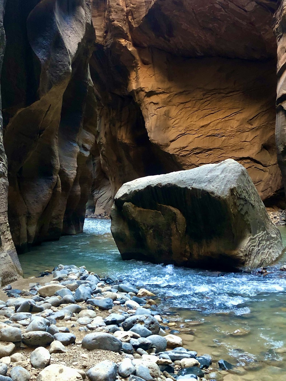 a river running through a narrow canyon next to rocks
