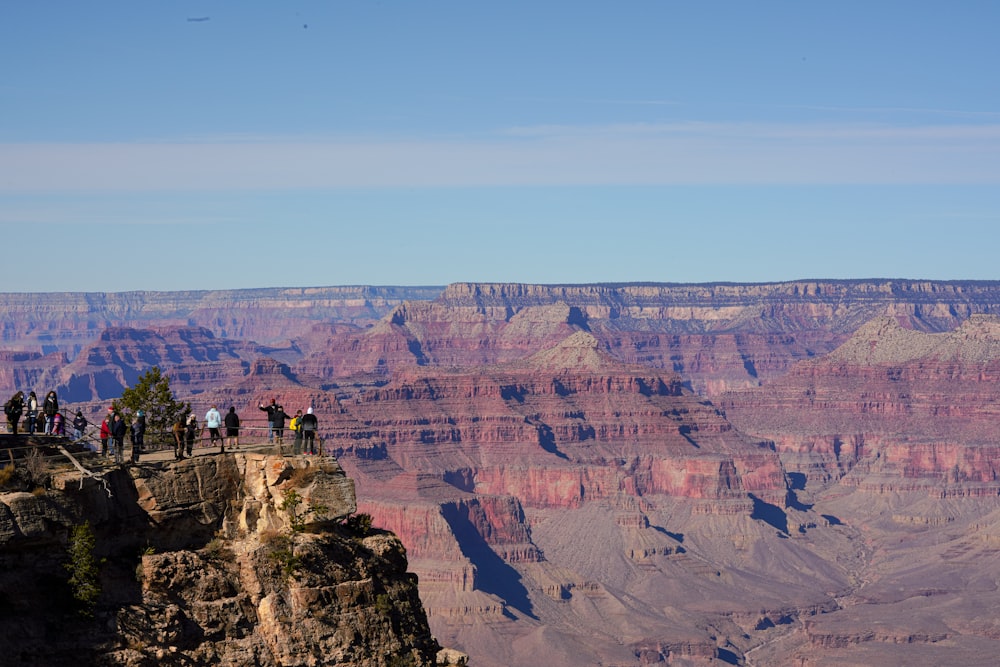 people standing on brown rock formation during daytime