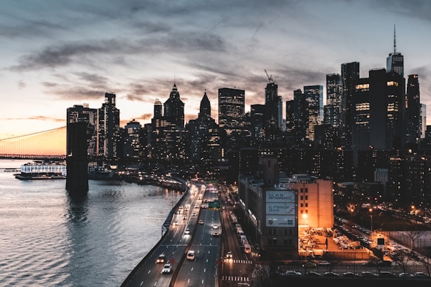 city buildings near body of water during night time
