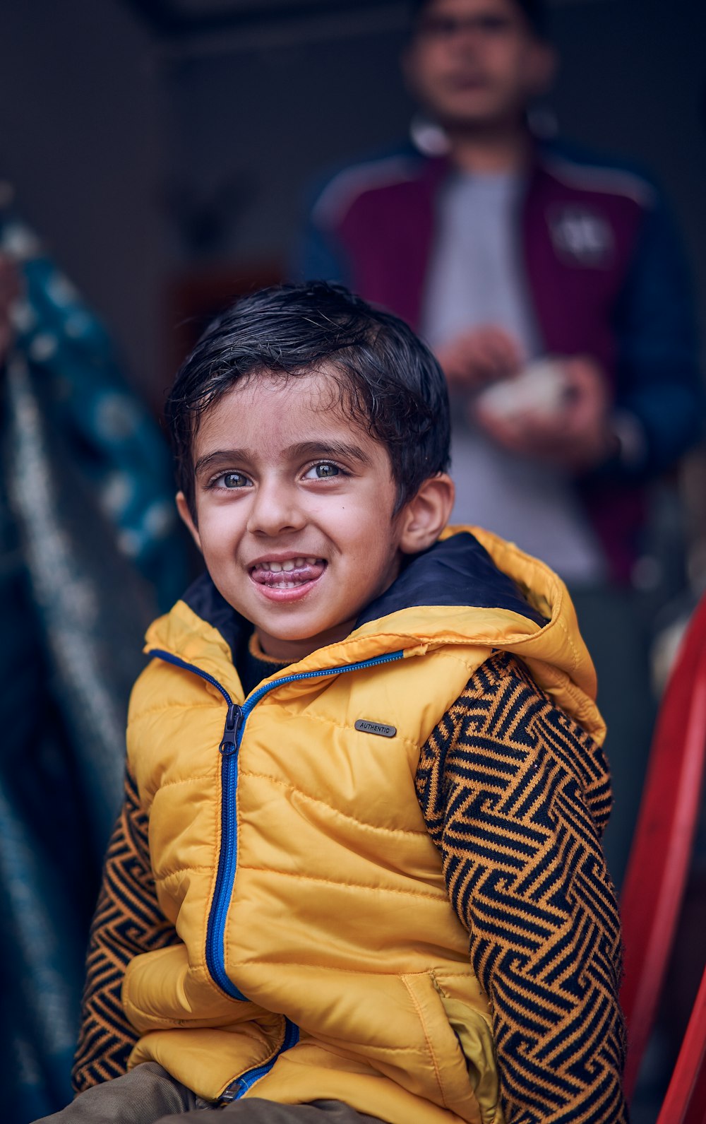 Foto niño con chaqueta amarilla y azul con cremallera sonriendo – Imagen Chico gratis en