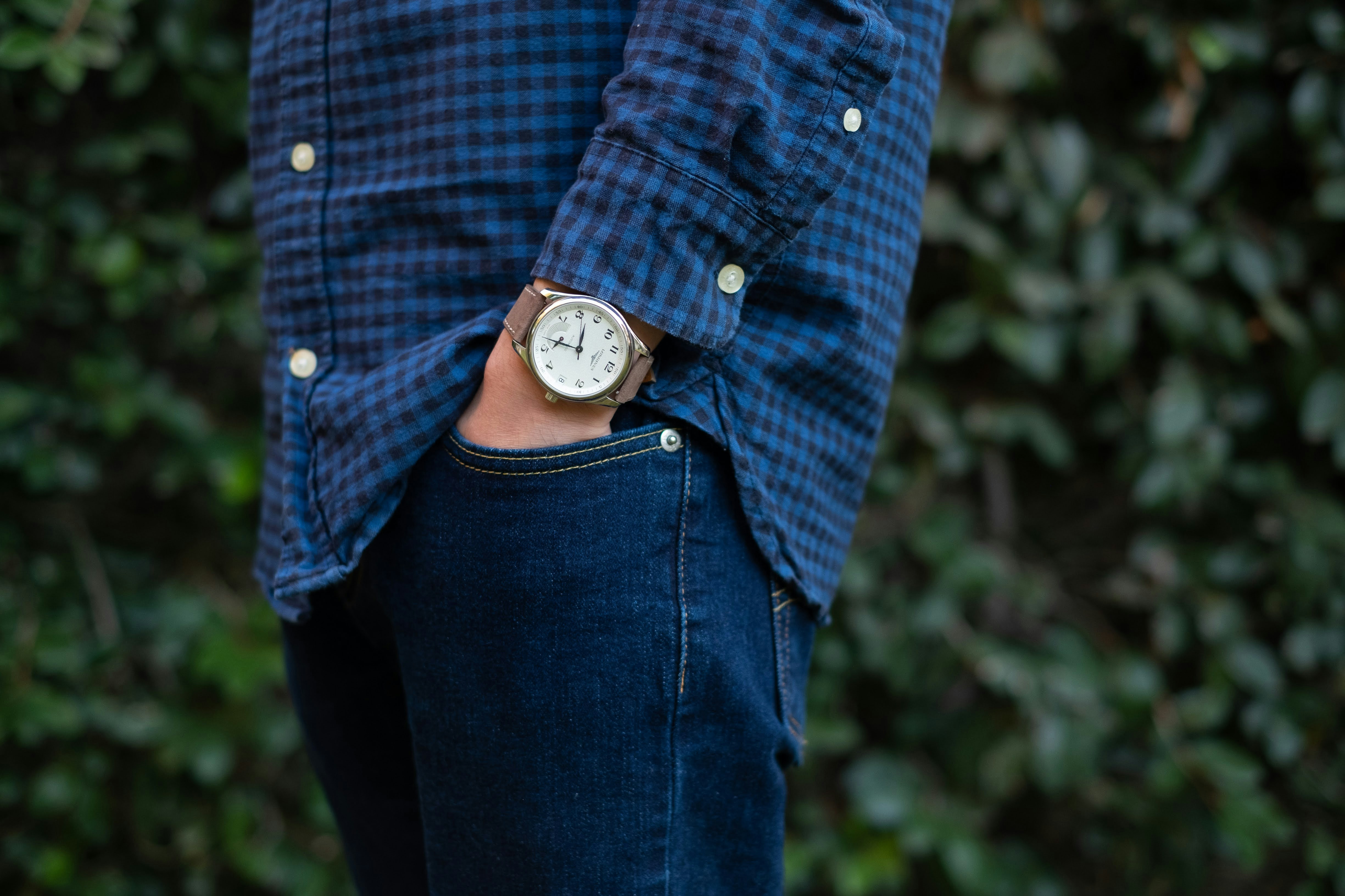 person in blue and white plaid button up shirt and blue denim jeans