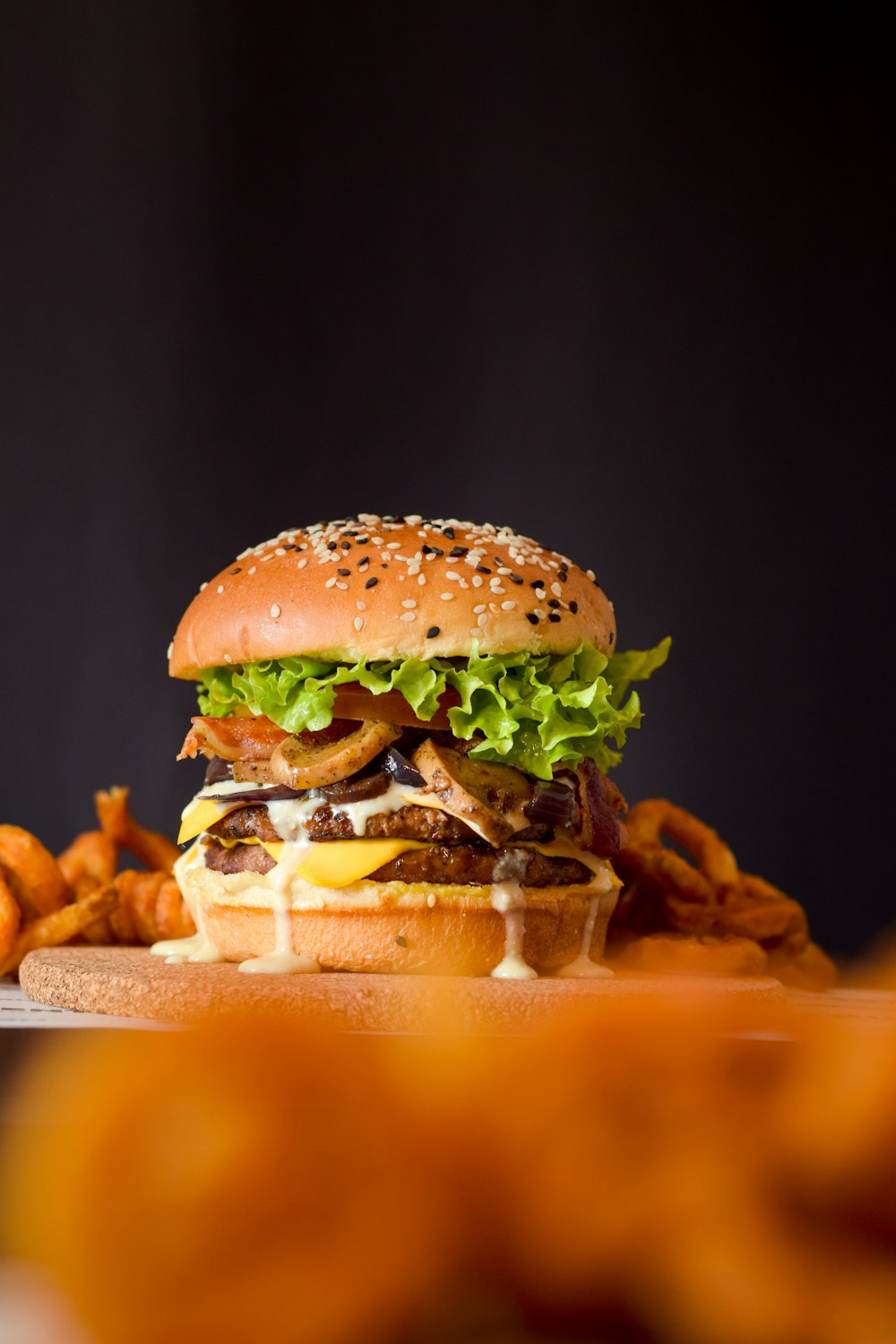 burger with lettuce and tomato on brown wooden tray