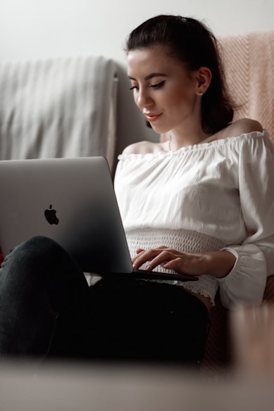 woman in white long sleeve shirt using macbook and exploring mindfulness workshop offering