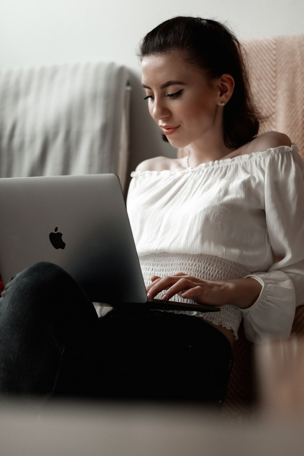 mulher na camisa branca da manga comprida usando macbook