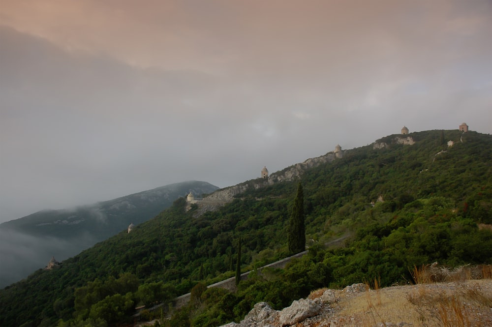 montaña cubierta de hierba verde bajo cielo nublado durante el día