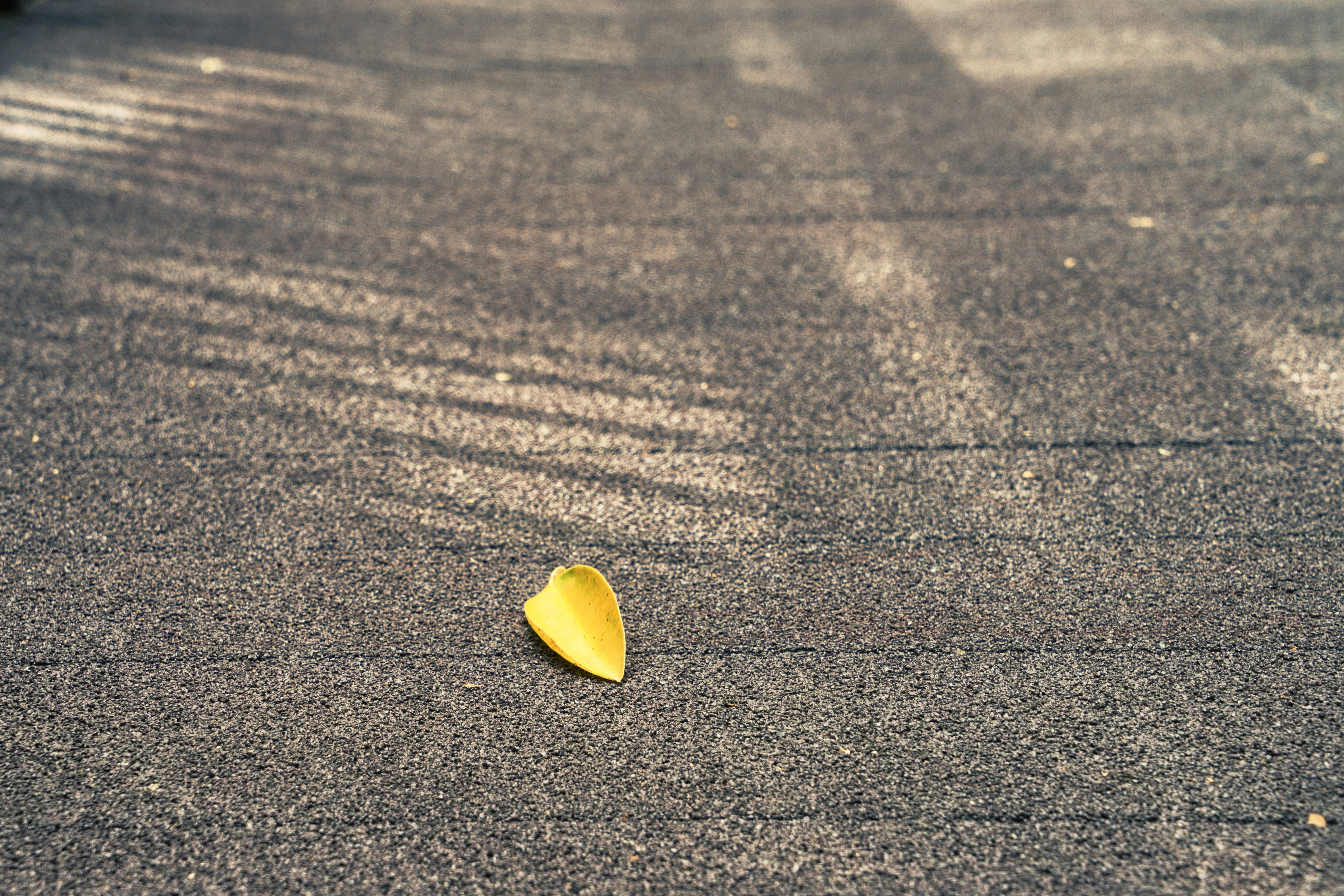 cuore giallo a forma di cuore su pavimento di cemento grigio