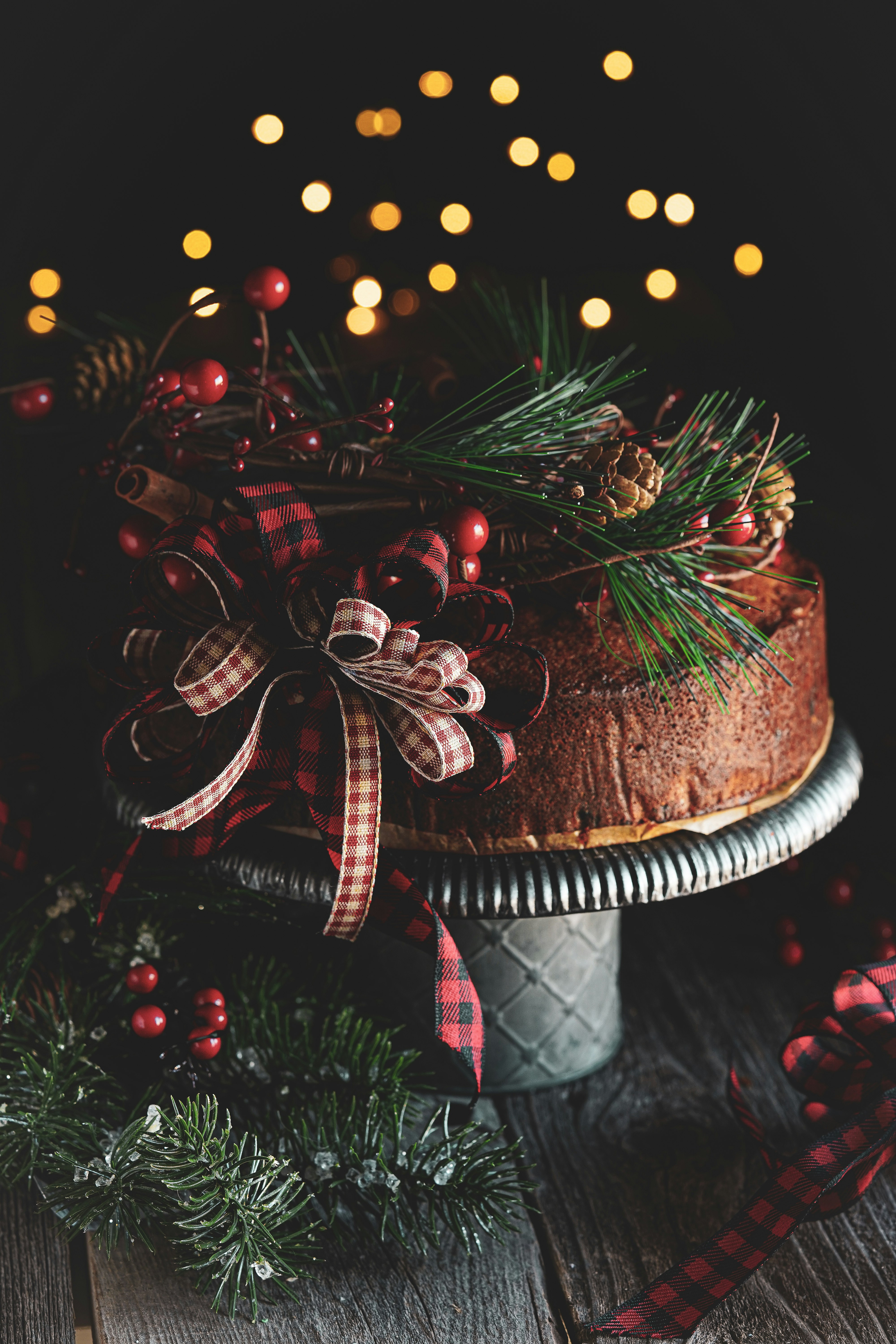 brown and white cake with red and white ribbon on brown wooden table