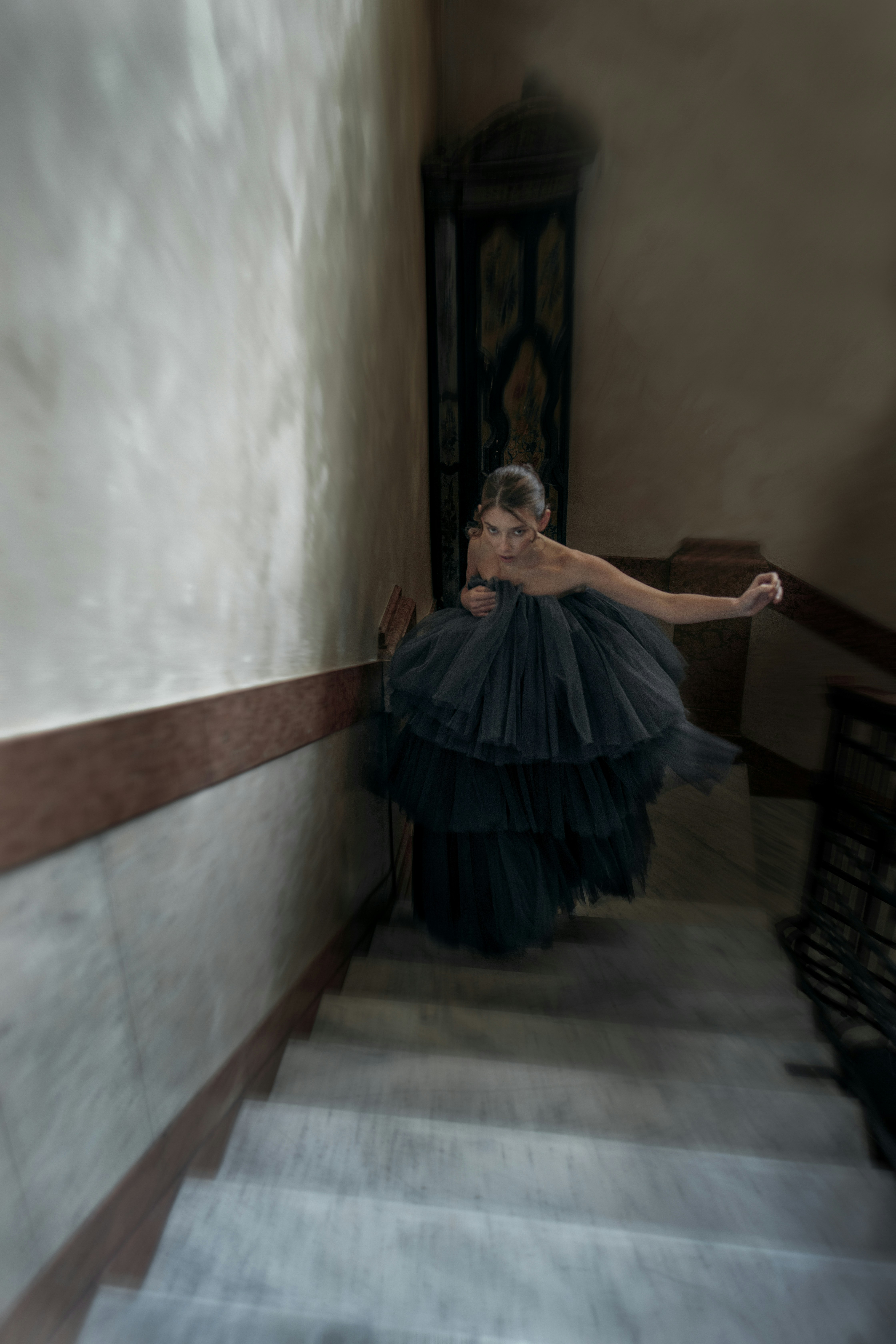 woman in blue dress standing on brown wooden staircase