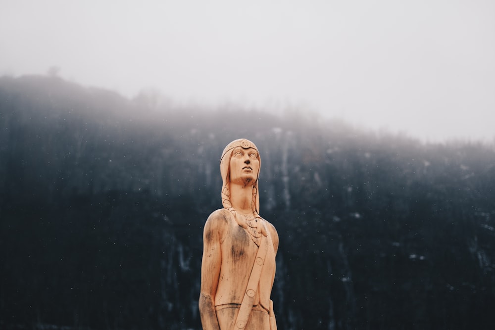 Statue de femme en manteau marron