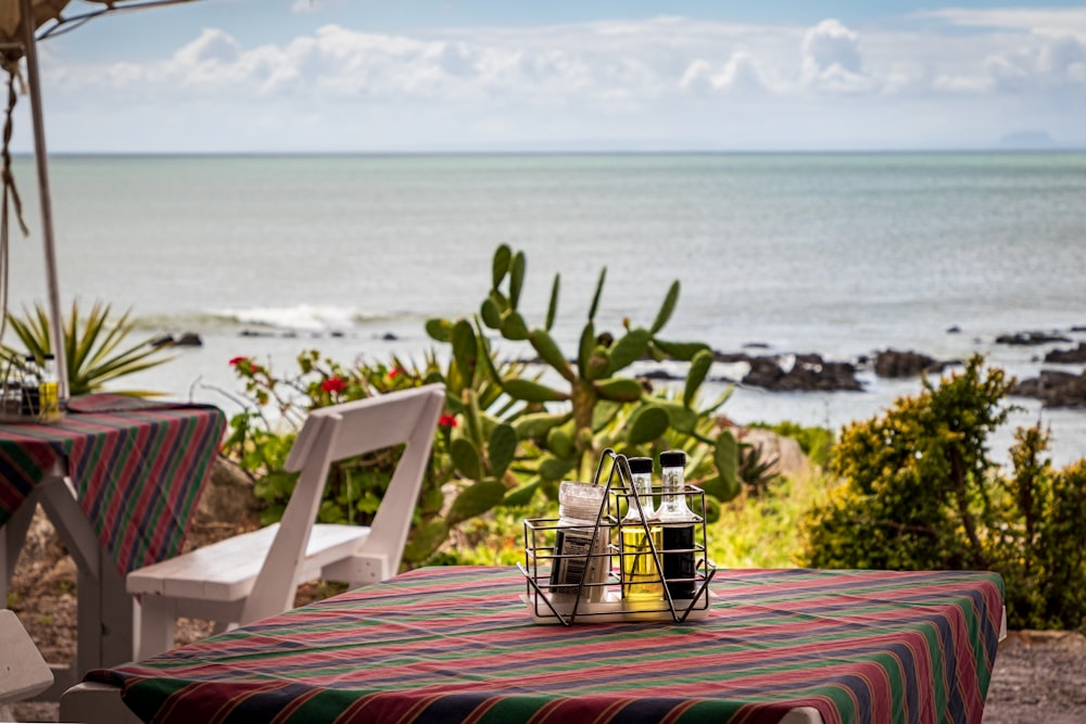 white wooden chair on red and white stripe table near beach during daytime