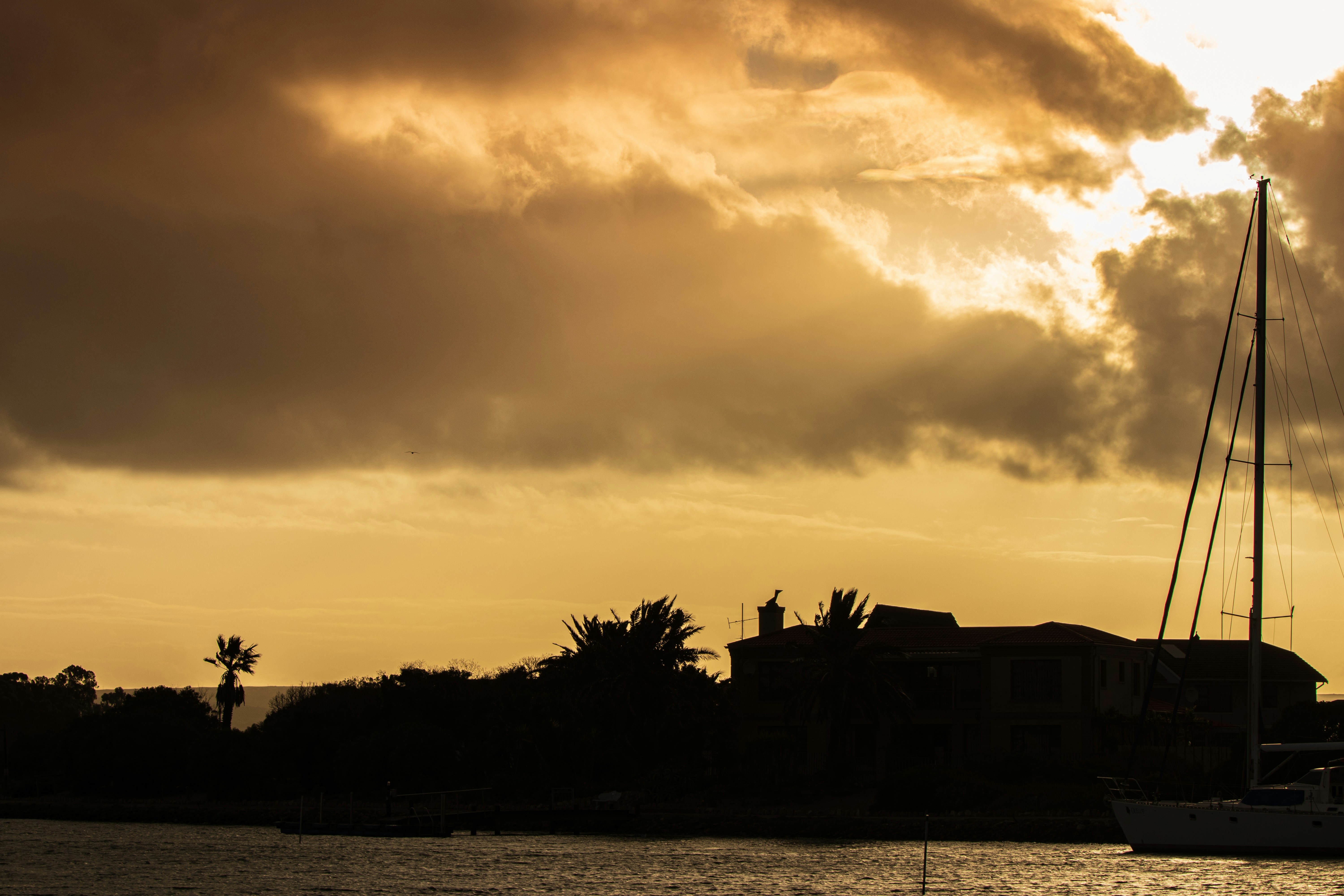 Silhouette of holiday homes on a marina at sunset on a cloudy day