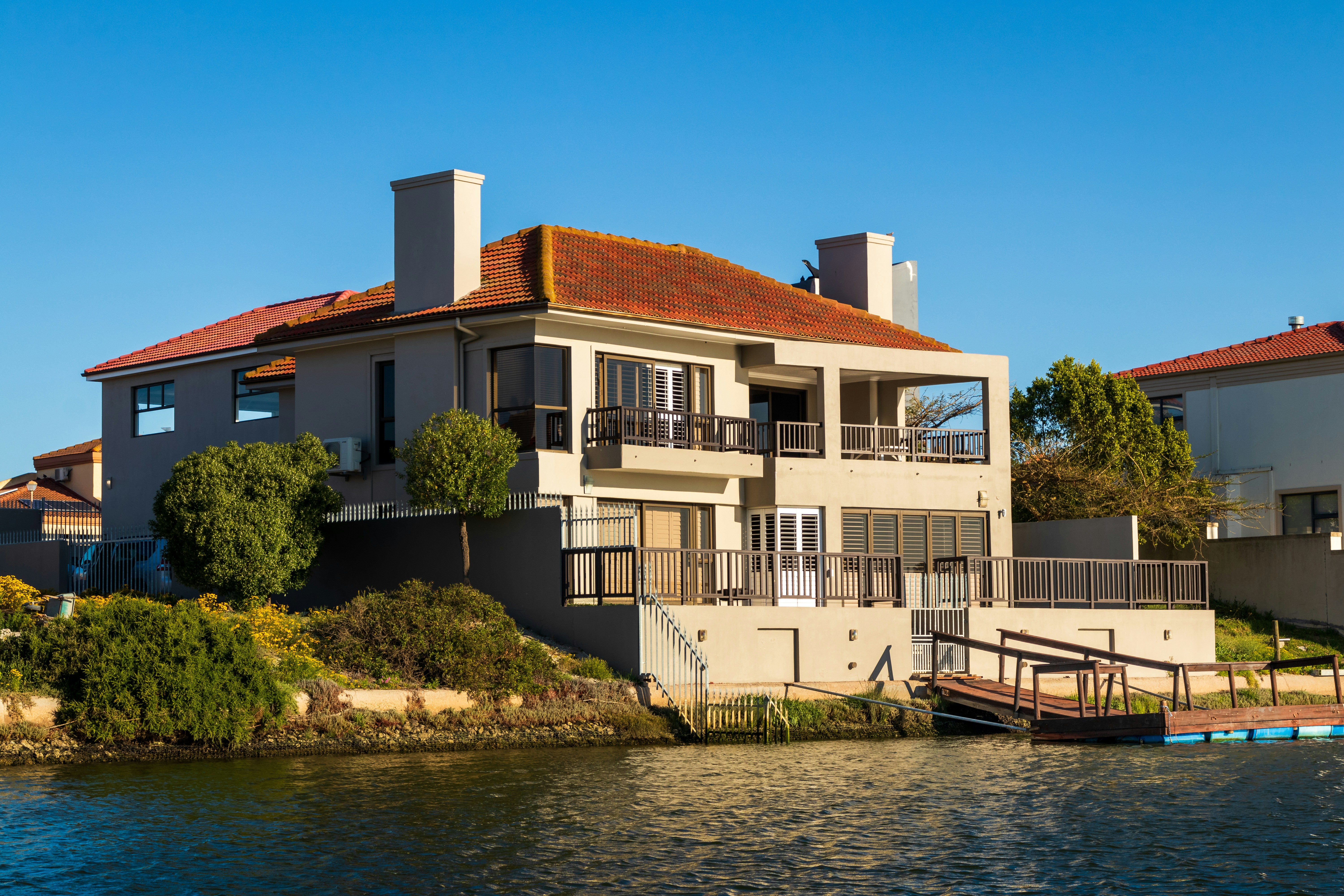 Luxury home on the bank of a river on a sunny day with blue skies