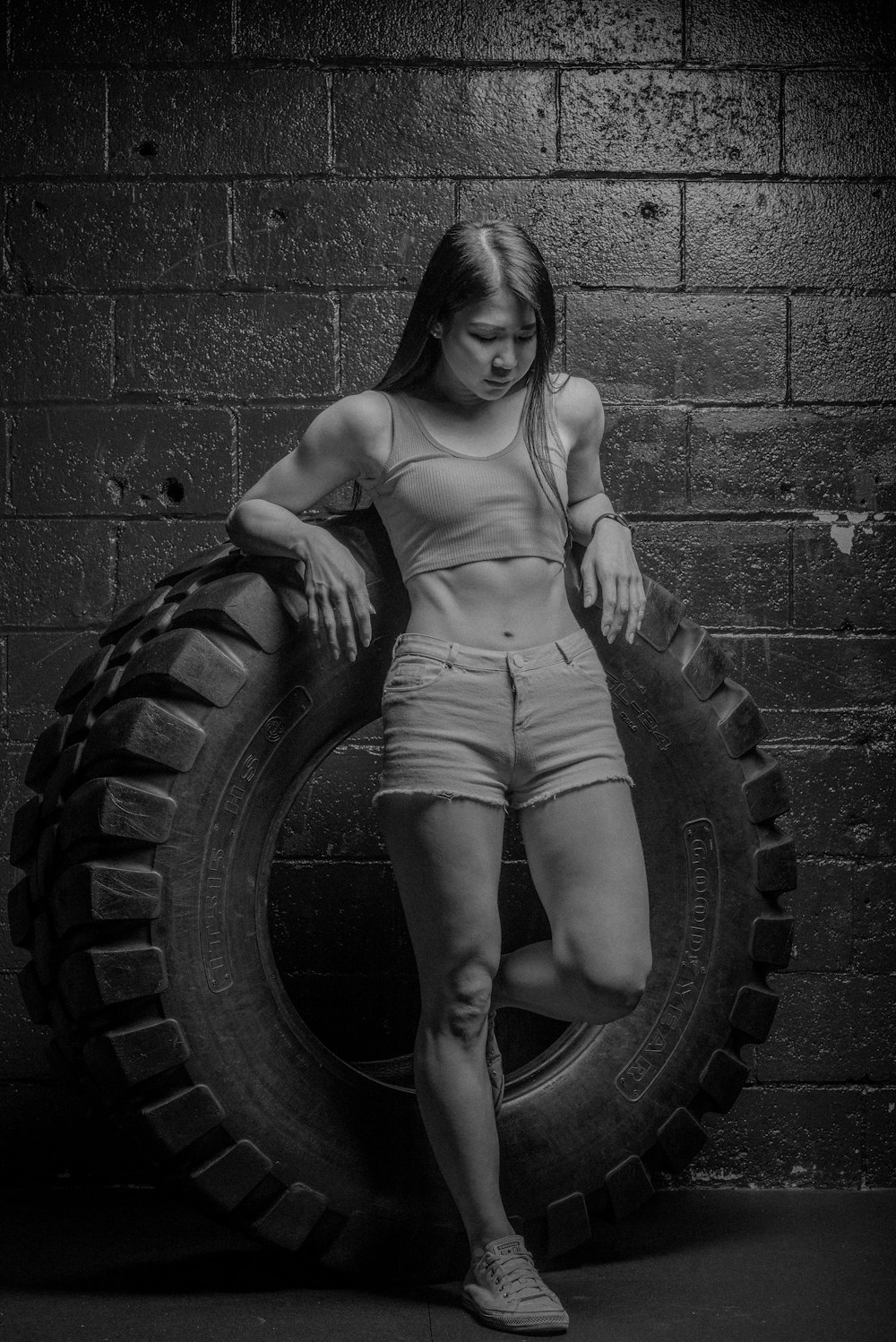 woman in white tank top and white shorts sitting on wheel