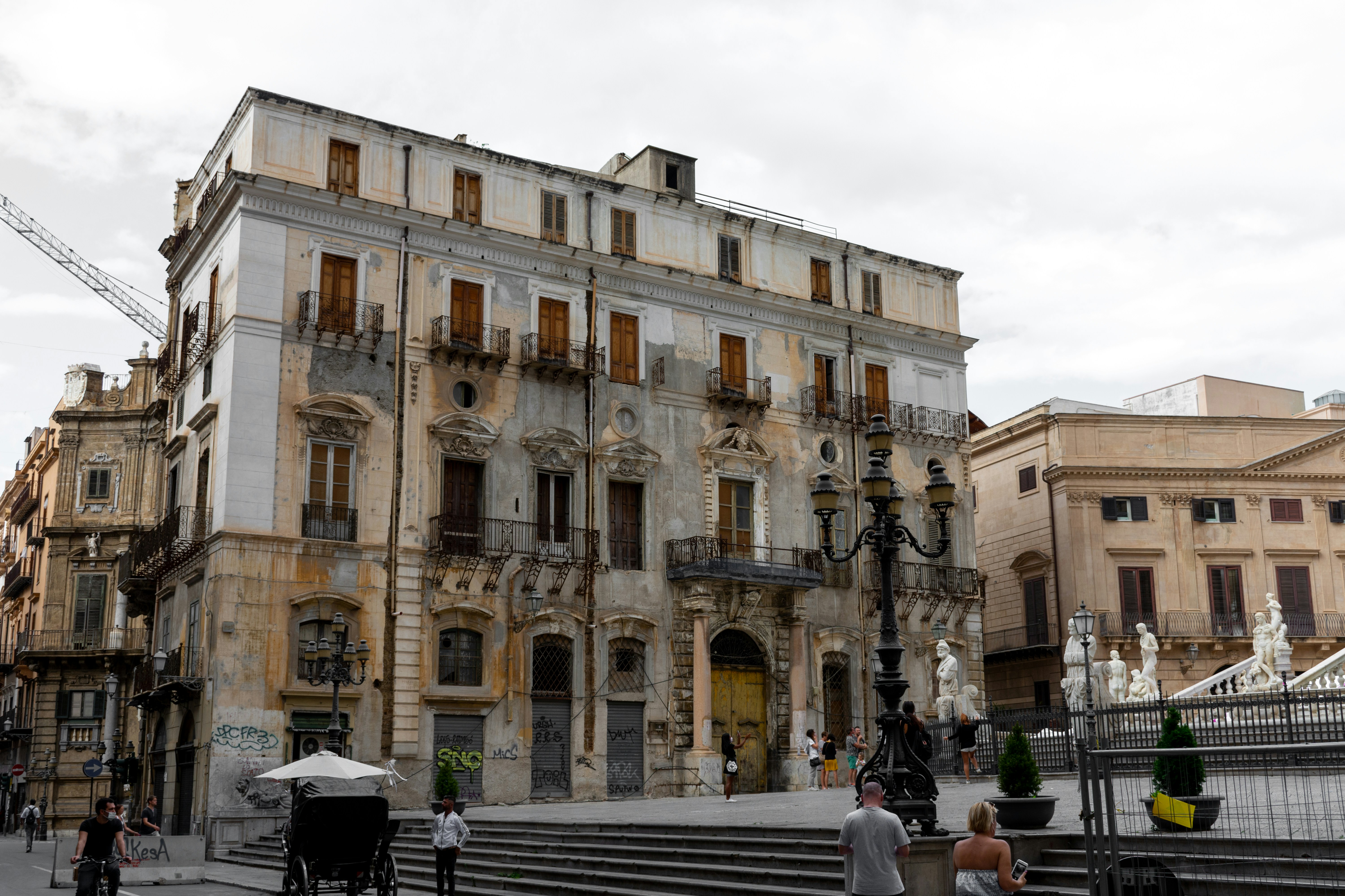 people sitting on bench near beige concrete building during daytime, 