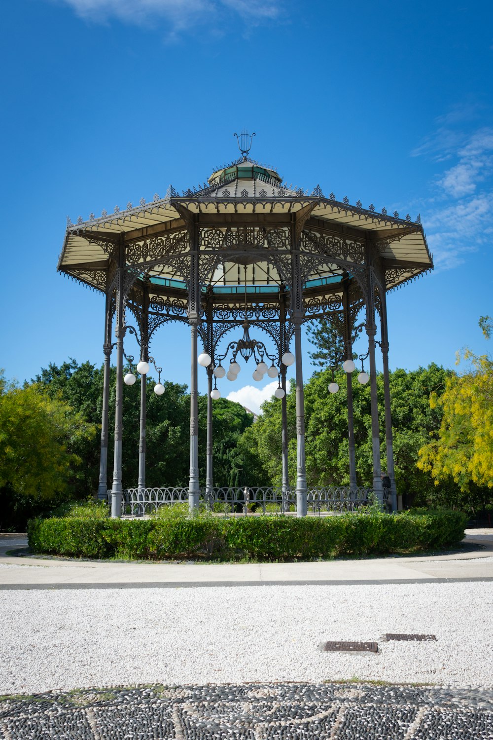 Bâtiment en béton brun et blanc entouré d’arbres sous un ciel bleu pendant la journée