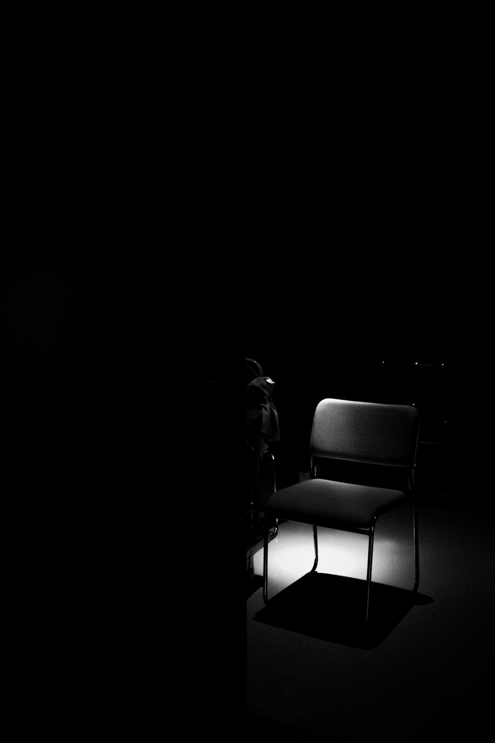 grayscale photo of chair with black background