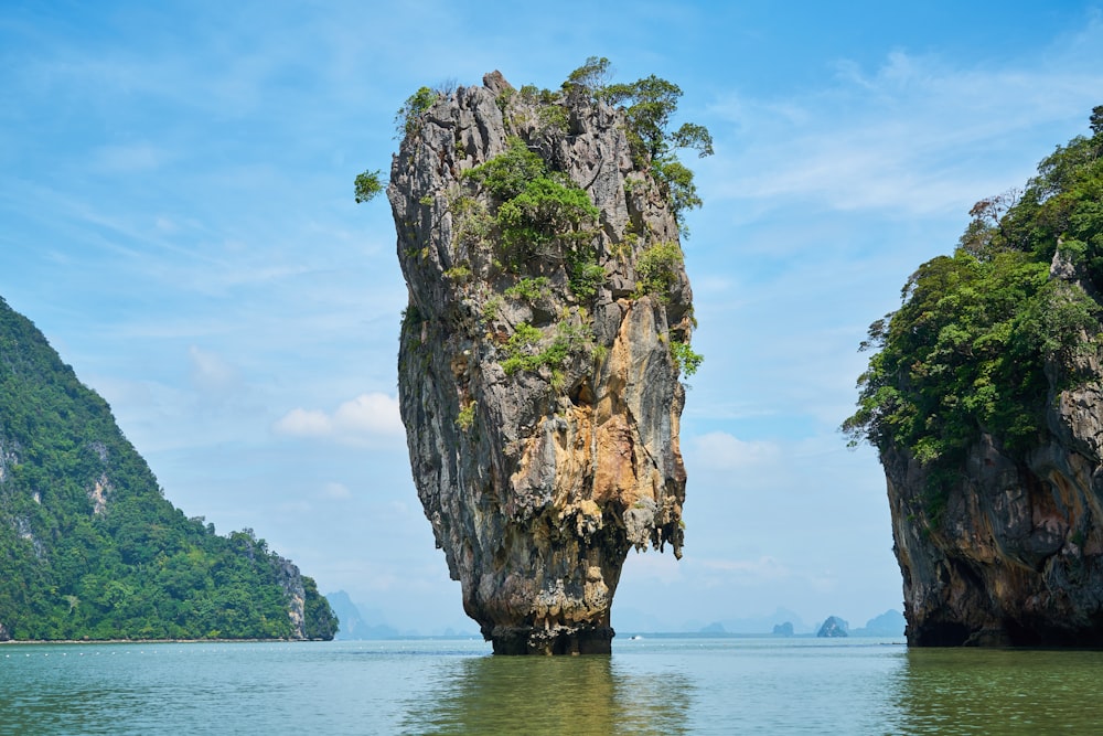 brown rock formation on body of water during daytime