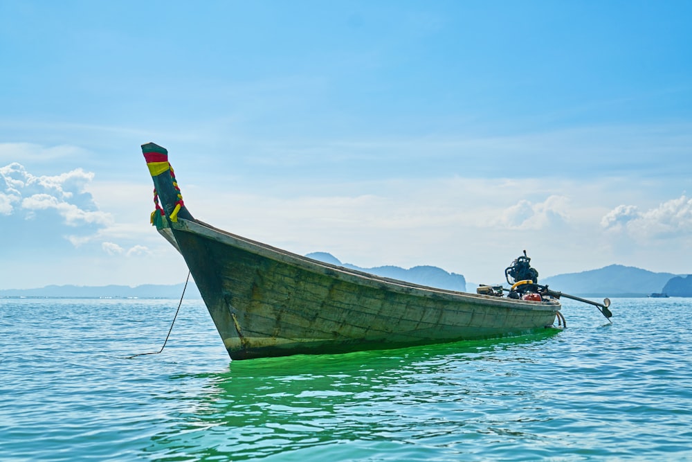 man in black shirt and yellow shorts riding on boat during daytime