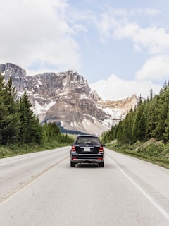 black car on road near mountain range