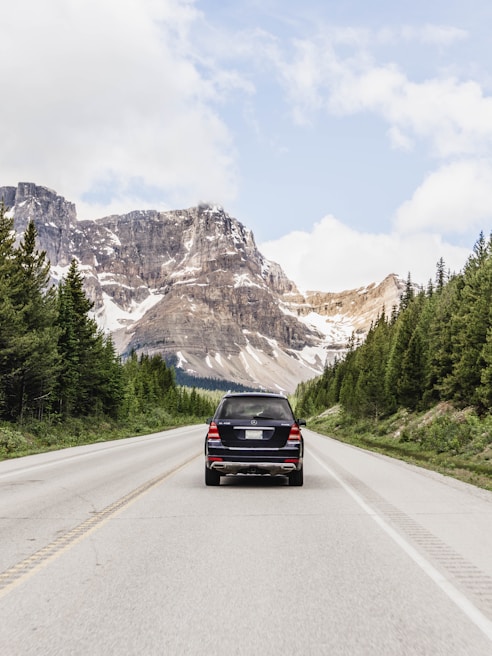 black car on road near mountain range