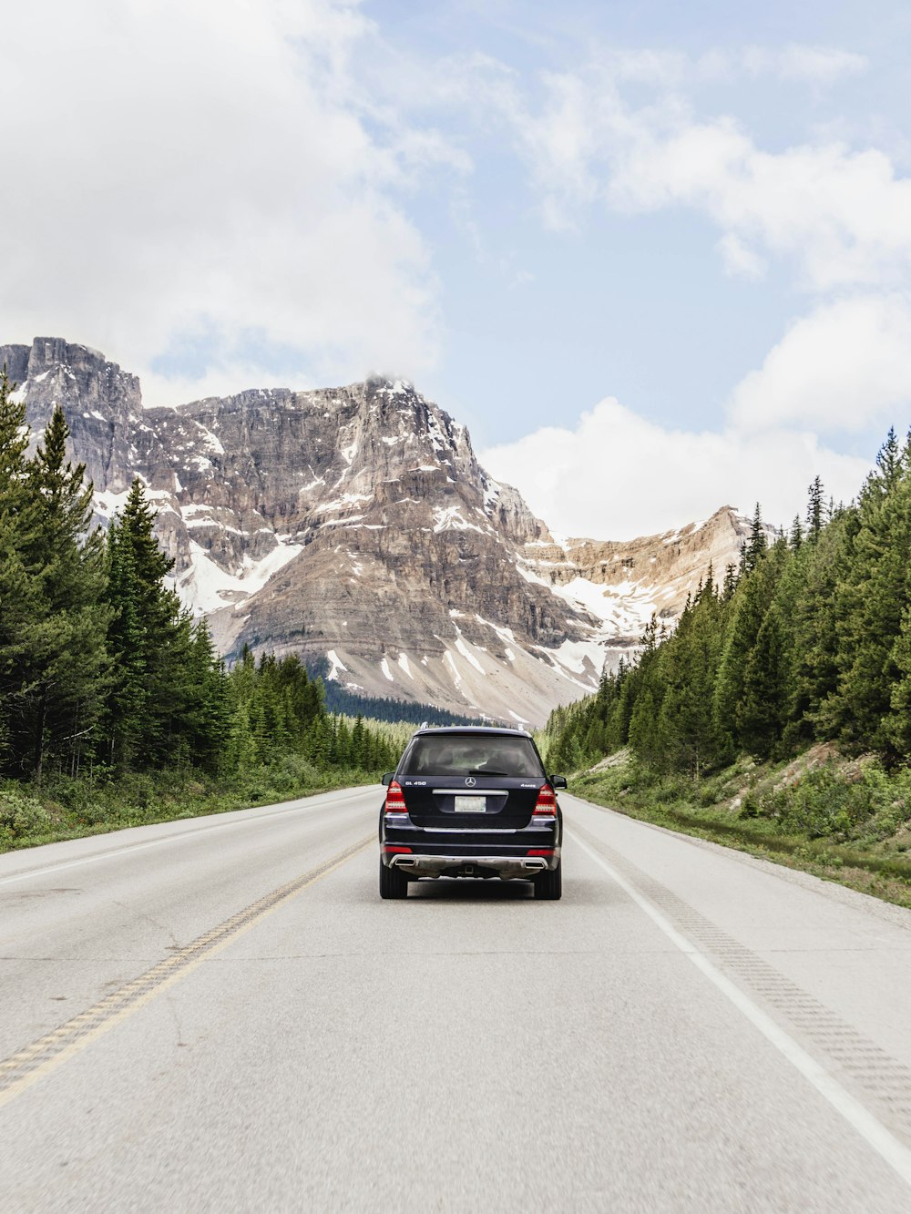 black car on road near mountain range