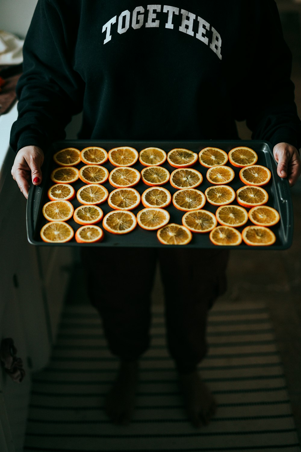 person holding tray of cupcakes
