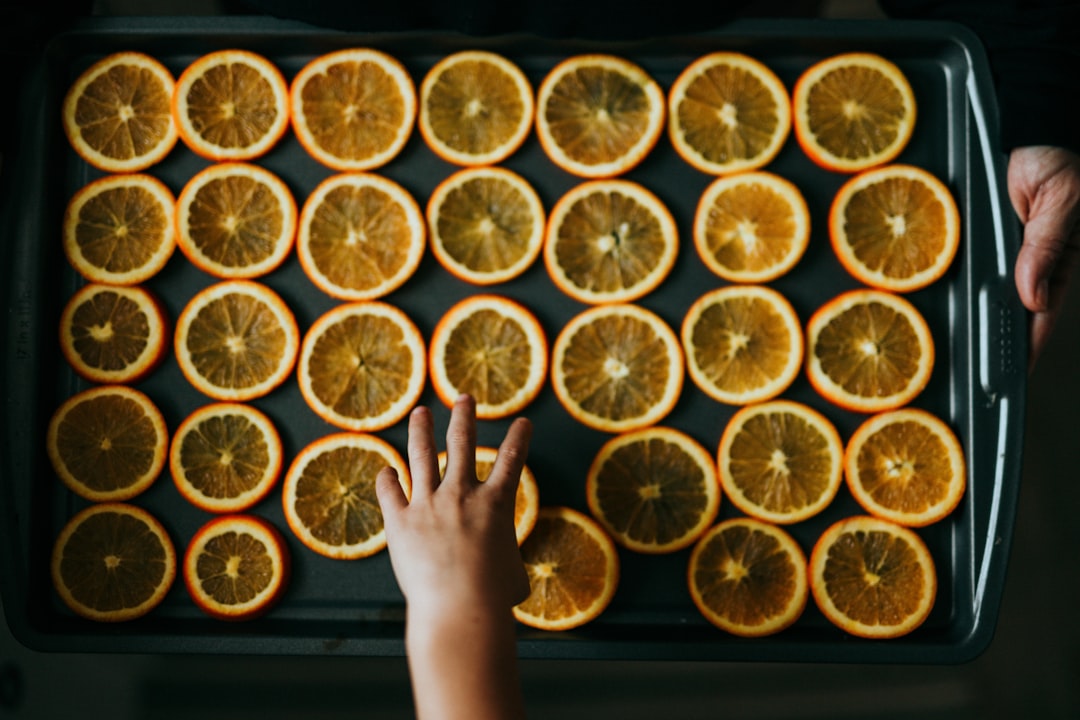 person holding sliced orange fruits