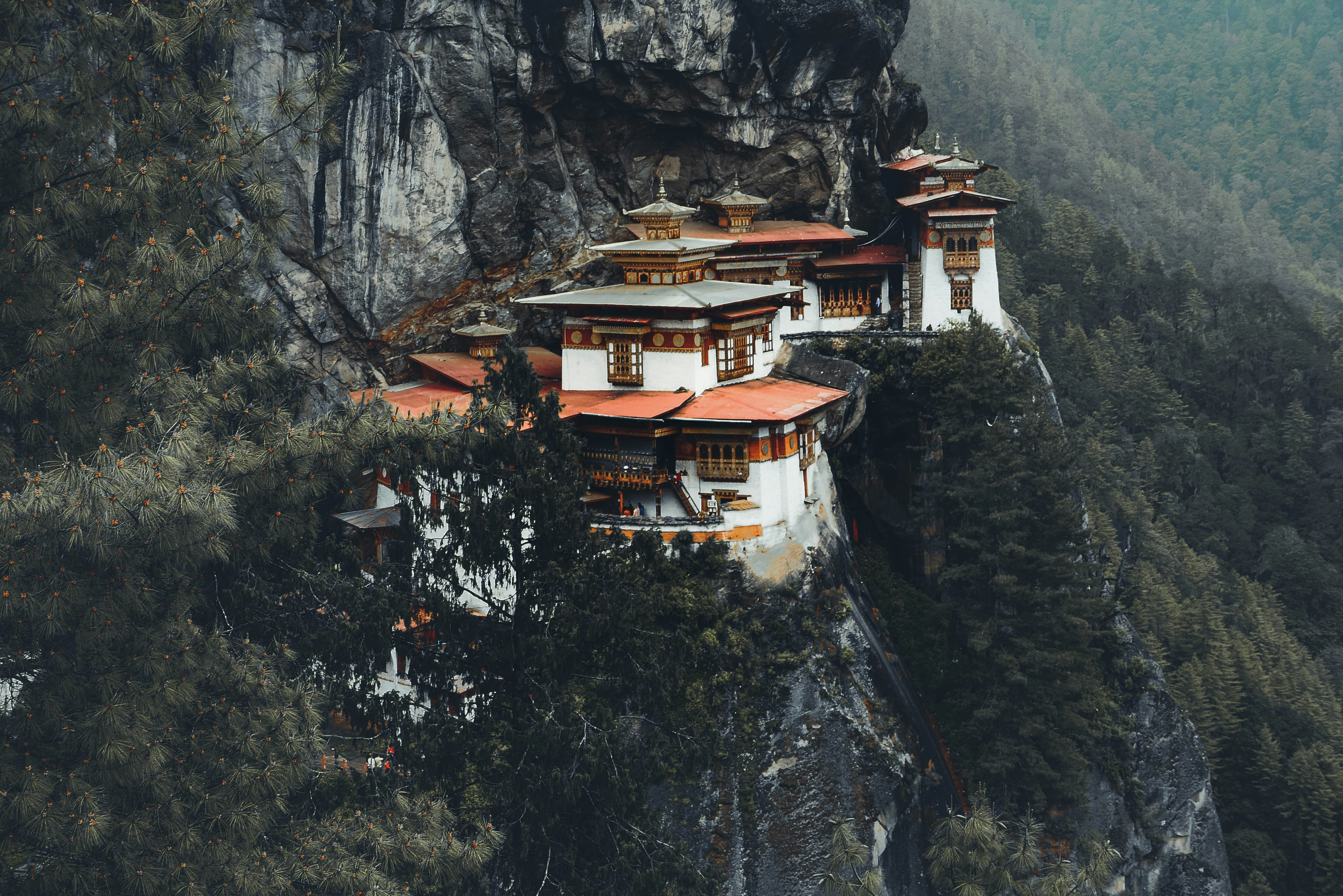 white and brown concrete house on rocky mountain during daytime