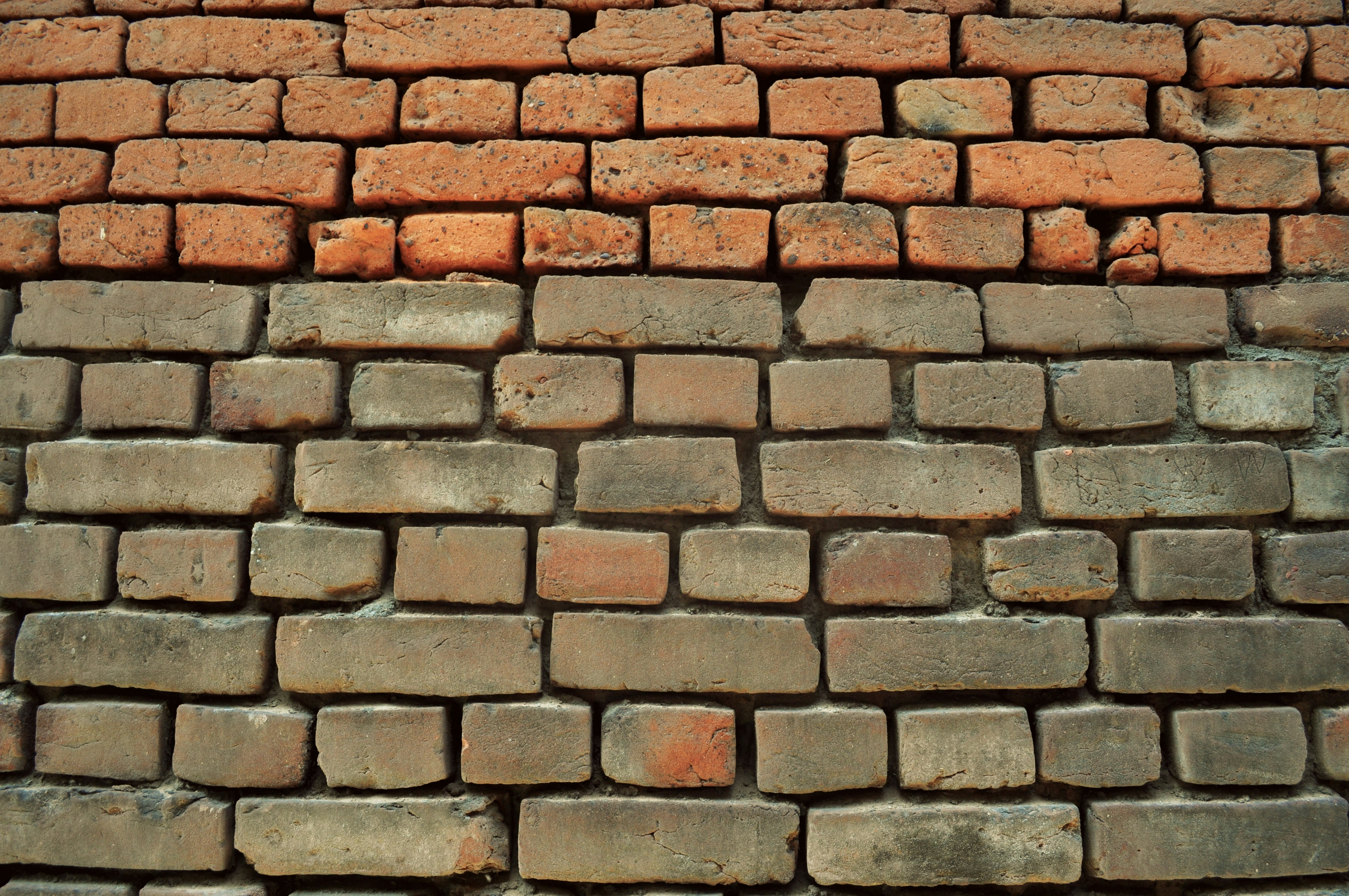muddy brick wall with weathered mortar