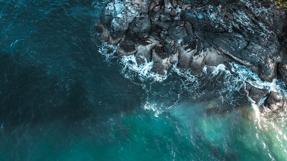 water waves hitting rocks during daytime