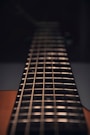 brown acoustic guitar in close up photography