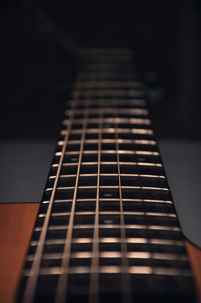 Guitarrista afinando guitarra acústica com afinador