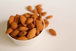 brown almond nuts on white ceramic bowl