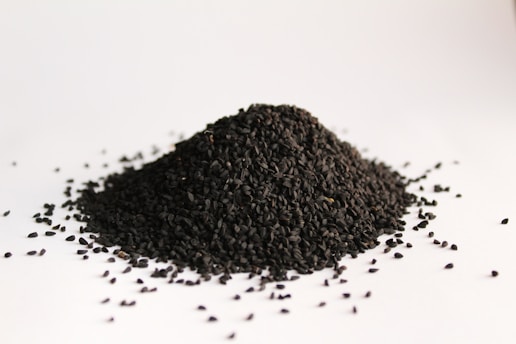 black cummin seeds on white surface