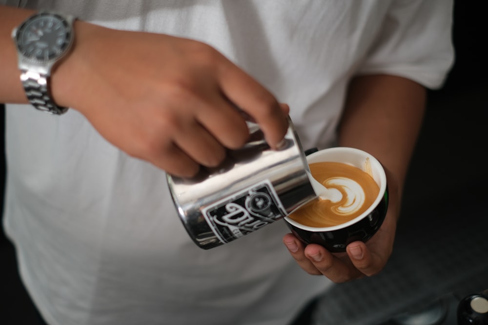 Person mit weißem Keramikbecher mit Kaffee