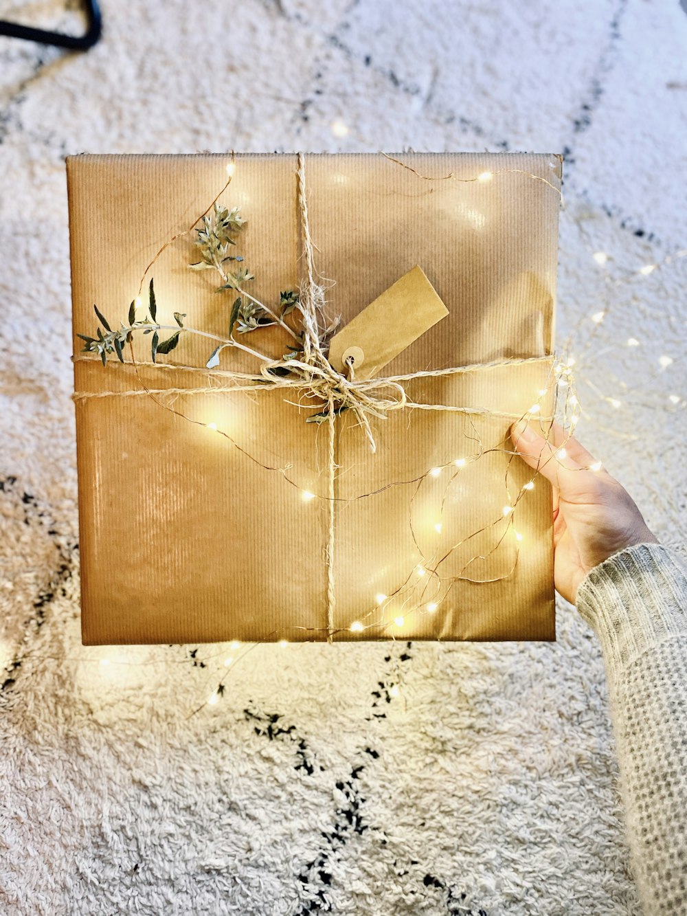 Caja de regalo marrón sobre mesa de mármol blanco y negro