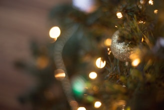 A close-up of a gold-foiled Christmas card shimmering under soft holiday lighting.