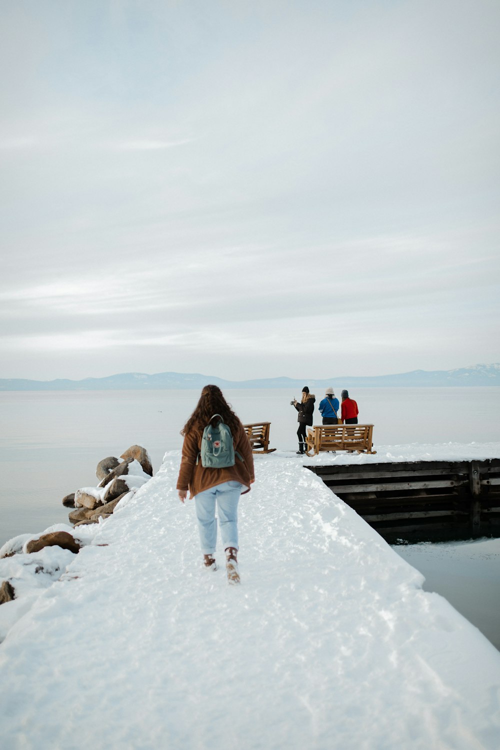 woman in blue denim jacket standing on snow covered ground during daytime