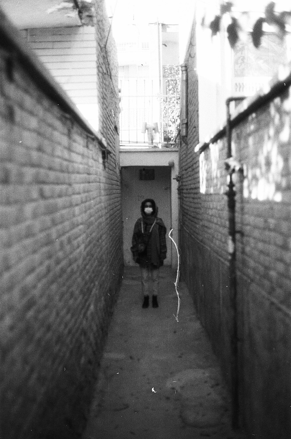 grayscale photo of woman in black jacket walking on hallway