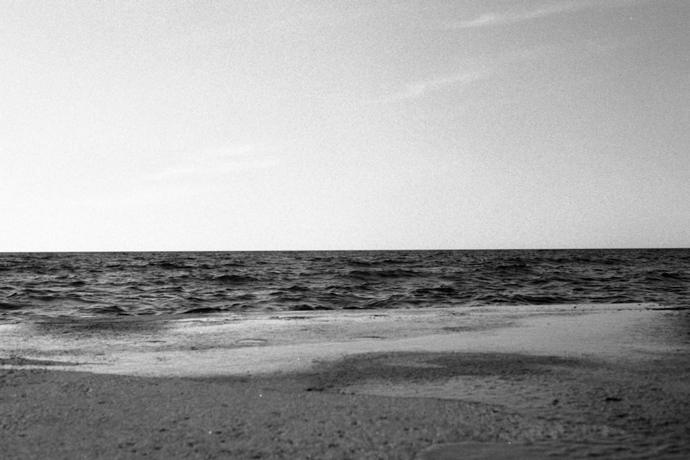 grayscale photo of sea waves crashing on shore