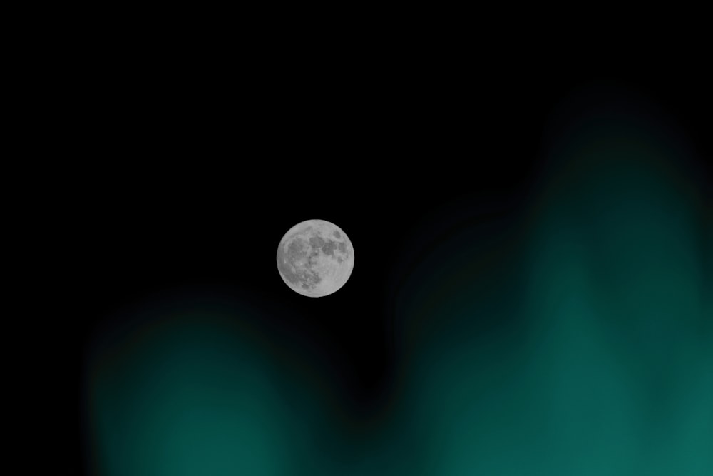 silver round coin on green surface