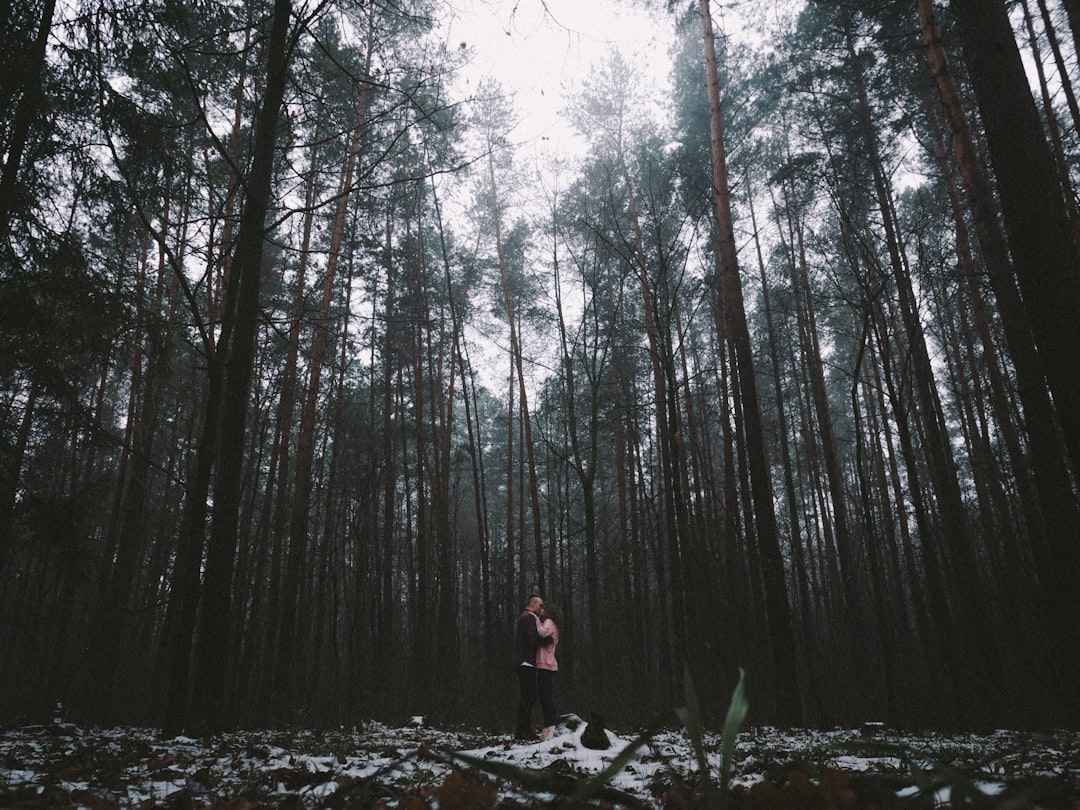 woman in black jacket standing on forest during daytime