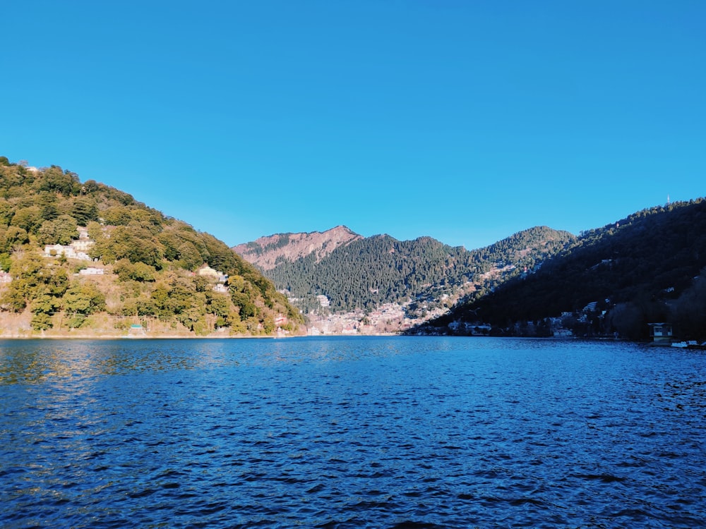 green and brown mountains beside body of water during daytime