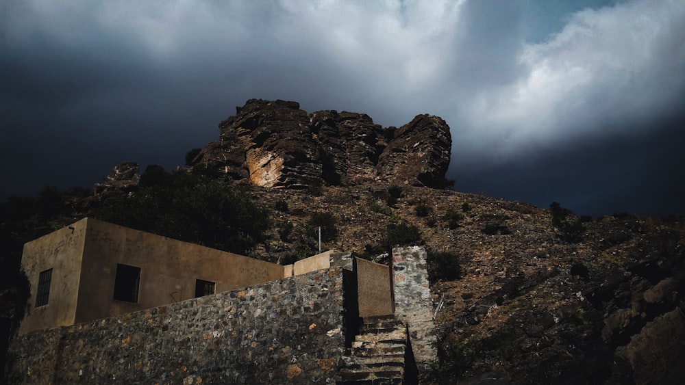 brown concrete building on top of mountain under cloudy sky during daytime