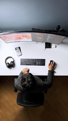 Close-up of a programmer coding a gaming application with VR headset on the desk.