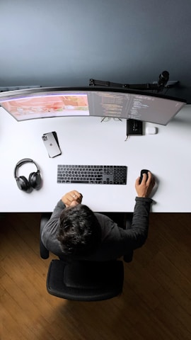Umair Raza working at his desk with dual monitors, focused on managing client projects.